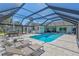 A covered pool featuring lounge chairs, an outdoor dining area, and a pristine pool at 3725 Spyglass Hill Rd, Sarasota, FL 34238