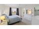 Well-lit bedroom featuring a light gray bedspread, a dresser, and curtains that filter in light at 3917 Ashwood Ln # 57, Sarasota, FL 34232