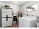 Efficient laundry room with washer, dryer, storage cabinet, and window for natural light at 3917 Ashwood Ln # 57, Sarasota, FL 34232