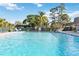 Large community pool featuring clear blue water surrounded by lush greenery on a bright day at 3917 Ashwood Ln # 57, Sarasota, FL 34232