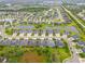 An aerial view of a neighborhood featuring houses with well-maintained lawns and scenic ponds at 4021 Wildgrass Pl, Parrish, FL 34219