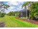 Expansive backyard featuring lush landscaping and a screened-in lanai for outdoor enjoyment at 4021 Wildgrass Pl, Parrish, FL 34219