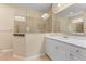 Bright bathroom with white cabinetry, shower and glass enclosure with neutral tile and grab bars at 4021 Wildgrass Pl, Parrish, FL 34219