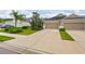 Features a lush green lawn, well-manicured landscaping, and a two-car garage with a spacious concrete driveway at 4021 Wildgrass Pl, Parrish, FL 34219