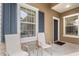 Welcoming front porch with seating, blue shutters, and a charming entrance door at 4021 Wildgrass Pl, Parrish, FL 34219