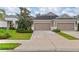 Attached two car garage of a well-maintained tan and white home with nicely manicured landscaping at 4021 Wildgrass Pl, Parrish, FL 34219