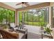 Screened lanai provides a serene outdoor living space with seating and views of the tropical landscape at 4021 Wildgrass Pl, Parrish, FL 34219