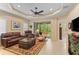 Comfortable living room with leather furniture, ceiling fan, and screened-in lanai at 4021 Wildgrass Pl, Parrish, FL 34219