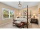 Elegant main bedroom with a four-poster bed, chandelier, and plantation shutters at 4021 Wildgrass Pl, Parrish, FL 34219