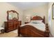 Main bedroom suite showcasing a decorative wooden bed frame and matching dresser at 4021 Wildgrass Pl, Parrish, FL 34219