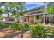 Charming home with a red front door, a covered front porch, and lush landscaping with many palm trees at 4063 Woodview Dr, Sarasota, FL 34232