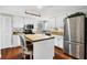 Well-lit kitchen featuring white cabinets, an island with butcher block top, and stainless steel appliances at 4063 Woodview Dr, Sarasota, FL 34232