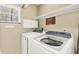 Clean laundry room with modern washer and dryer units, plus shelving and cabinetry at 4063 Woodview Dr, Sarasota, FL 34232