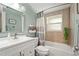 This bathroom features blue-green walls, a shower-tub combo, and a modern sink and vanity at 4311 2Nd E Ave, Bradenton, FL 34208