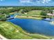 Scenic aerial view of lush golf course, serene lake, and connecting bridges in a beautiful setting at 4406 Baltry Ct, Bradenton, FL 34211