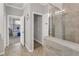 Hallway to a bathroom featuring a tiled shower, double sinks, and tiled floors at 4406 Baltry Ct, Bradenton, FL 34211