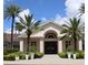 Elegant clubhouse exterior showcasing a symmetrical design, arched entrance, and tropical palm trees at 4406 Baltry Ct, Bradenton, FL 34211
