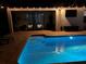 A screened pool and spa illuminated at night feature patio with a seating area at 4406 Baltry Ct, Bradenton, FL 34211