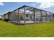 A screened pool is surrounded by a patio and overlooks the grassy backyard at 4406 Baltry Ct, Bradenton, FL 34211