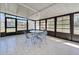 Enclosed patio features tile flooring, bright windows, and a ceiling fan above the dining area at 441 Venetia Ave, North Port, FL 34287