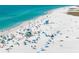 Aerial view of a white sand beach bustling with people, turquoise ocean water, and blue skies at 4711 Ocean Blvd, Sarasota, FL 34242