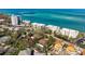 Aerial view of the property featuring a swimming pool, lush landscaping, and close proximity to the beach at 4711 Ocean Blvd, Sarasota, FL 34242