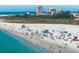 Aerial view of a white sand beach bustling with people, turquoise ocean water, and blue skies at 4711 Ocean Blvd, Sarasota, FL 34242