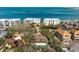 Aerial view of the property showcasing a swimming pool and mature landscaping near white sandy beaches at 4711 Ocean Blvd, Sarasota, FL 34242