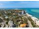 An aerial view of the home featuring a backyard swimming pool, lush landscaping and nearby white sandy beaches at 4711 Ocean Blvd, Sarasota, FL 34242
