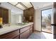 Bathroom featuring a spacious vanity, large mirror, and access to the outdoor balcony at 4711 Ocean Blvd, Sarasota, FL 34242