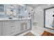 Bathroom featuring dual sinks, white cabinets and a shower at 4711 Ocean Blvd, Sarasota, FL 34242