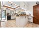 Bright kitchen featuring white cabinets, breakfast bar, and view of the pool at 4711 Ocean Blvd, Sarasota, FL 34242