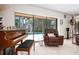 Bright living room with access to the pool, a piano, and comfy furniture at 4711 Ocean Blvd, Sarasota, FL 34242