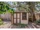 Small shed in backyard with double doors, a window, and surrounding natural foliage at 4711 Ocean Blvd, Sarasota, FL 34242