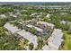 Aerial view of a residential community surrounded by lush greenery, lakes, and city views at 510 Spring Lakes Blvd, Bradenton, FL 34210