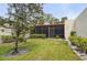 Serene backyard featuring lush lawn, shrubs, and a screened-in porch, perfect for outdoor enjoyment at 510 Spring Lakes Blvd, Bradenton, FL 34210
