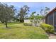 Landscaped backyard with a well-maintained lawn and mature trees bordering the patio space at 510 Spring Lakes Blvd, Bradenton, FL 34210