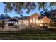 Backyard featuring a screened-in pool area, a gazebo, a fire pit, and well-maintained landscaping at 5151 Jasmine Way, Palm Harbor, FL 34685