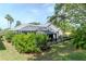 Landscaped backyard features a screened enclosure, gazebo, black fence, and lush greenery at 5151 Jasmine Way, Palm Harbor, FL 34685