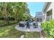 Spacious backyard featuring a gazebo, fire pit seating area, and lush landscaping at 5151 Jasmine Way, Palm Harbor, FL 34685