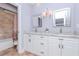 Bright bathroom with a double vanity featuring granite countertops and decorative mirrors at 5151 Jasmine Way, Palm Harbor, FL 34685
