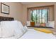 Bedroom with a tufted headboard bed and window seat with natural light streaming in at 5151 Jasmine Way, Palm Harbor, FL 34685