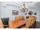 Formal dining room showcasing large dining table, chandelier, tray ceiling, and hardwood floors at 5151 Jasmine Way, Palm Harbor, FL 34685