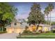Inviting home at dusk with illuminated windows, manicured landscaping, and a spacious three-car garage at 5151 Jasmine Way, Palm Harbor, FL 34685