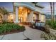 Inviting home entrance featuring stately columns, pendant lights, and a charming stone-accented porch at 5151 Jasmine Way, Palm Harbor, FL 34685