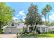 Inviting single-story home featuring mature landscaping, a two-car garage, and a charming covered entryway at 5151 Jasmine Way, Palm Harbor, FL 34685