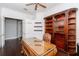 Spacious home office featuring a large desk, custom shelving, and hardwood flooring at 5151 Jasmine Way, Palm Harbor, FL 34685