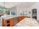 Bright kitchen featuring granite countertops, stainless steel appliances, and seamless flow into the adjacent living area at 5151 Jasmine Way, Palm Harbor, FL 34685