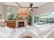 Bright living room featuring a fireplace, large windows, and access to the screened-in pool area at 5151 Jasmine Way, Palm Harbor, FL 34685