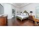 Well-lit main bedroom with hardwood floors, tray ceiling, and a comfortable sitting area at 5151 Jasmine Way, Palm Harbor, FL 34685